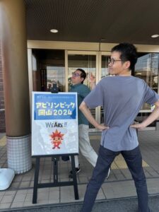 アビリンピック看板の前で楽しそうにポーズを決める徳光さんと清水さん